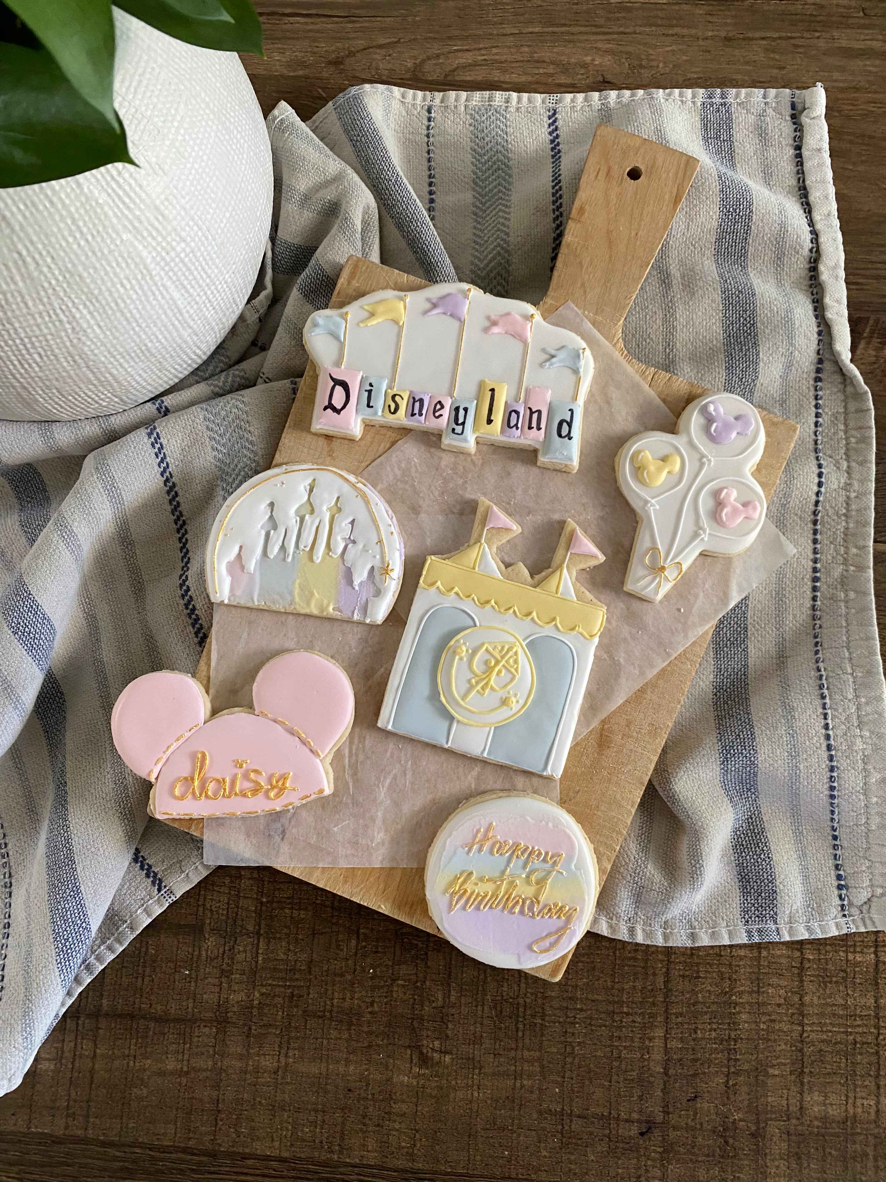 Disneyland themed birthday cookies with castle, Mickey ears, and balloons