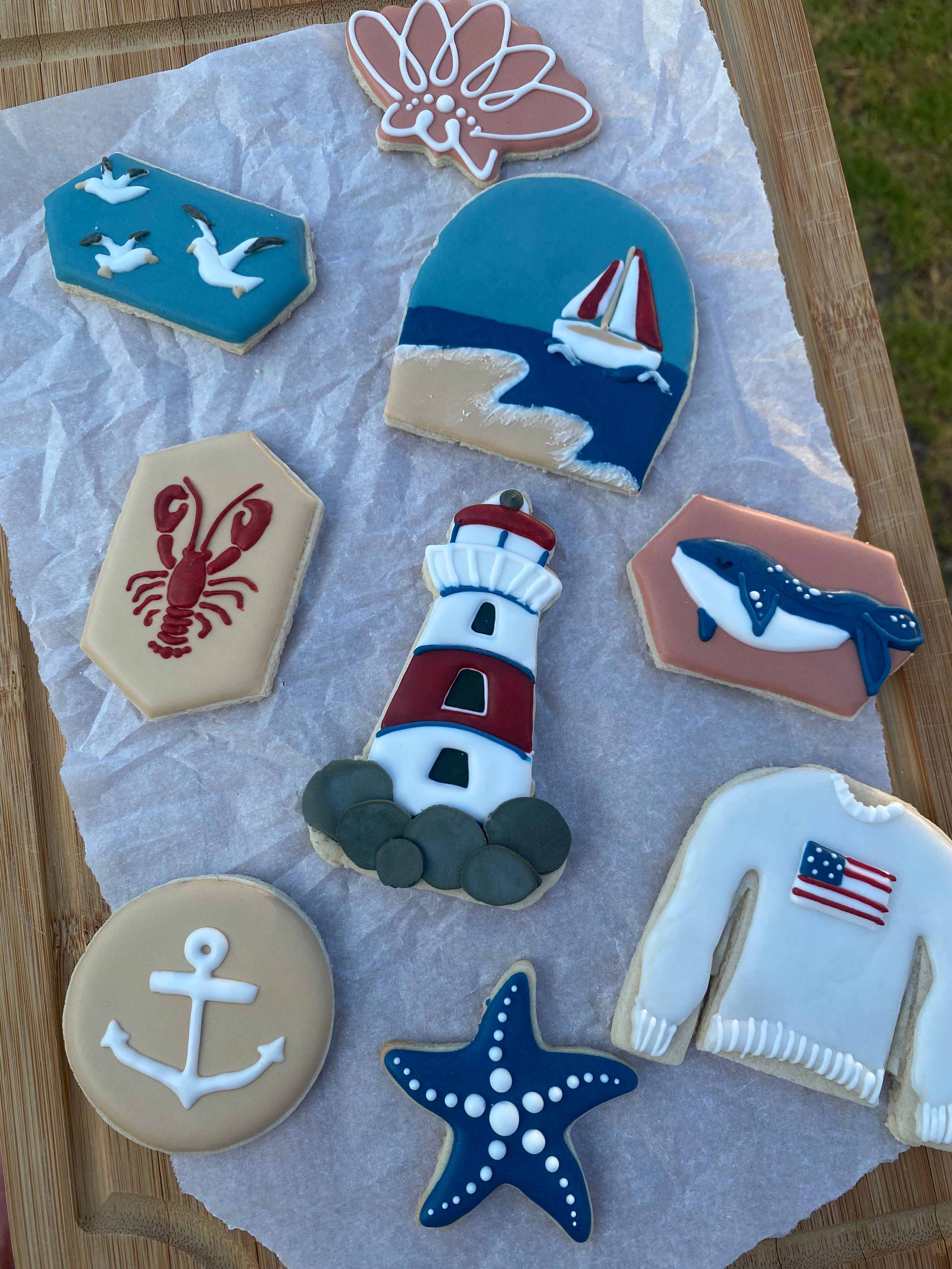 Nautical coastal themed cookies with lighthouse, sailboat, whale, lobster, and anchor